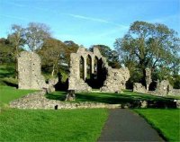 Inch Abbey: Inch was the site of a pre-Norman monastery,  in existence by 800 AD. Inch was raided by Vikings in 1001 and again in 1149 by the Irish.

The visible ruins are the extensive remains of the Cistercian Abbey founded by John de Courcy in 1180, after he had burned its predecessor. De Courcy was a strong supporter of the church. His wife Affreca, daughter of Godred, King of Man founded Grey Abbey in 1193, also Cistercian, and is buried there. Inch was established by monks from Furness in Lancashire, its 'mother house', and was almost certainly partly built by masons brought in by de Courcy from England.

Little is known of the abbey's later history except that it remained a centre of strong English influence. Monastic life ended with the dissolution of the monasteries when, in 1541, it was granted, with its lands, to Gerald, Earl of Kildare. By the late 19th century the buildings were badly ruined and overgrown, but excavation and repairs were carried out in 1914 when many of the architectural details were restored.
Photo: Pat Devlin

		CLICK FOR LARGER PICTURE